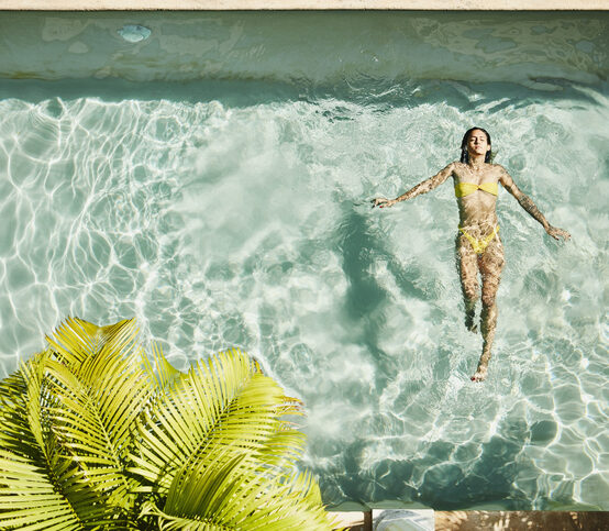 Card - Overhead view of woman floating on her back in pool at outdoor spa